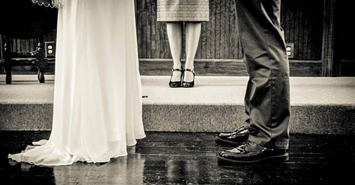 Bride and Groom standing with the officiant