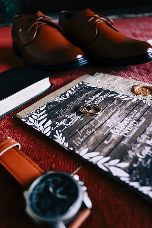 Grooms Shoes and watch, with wedding bands and an invitation as the focal point