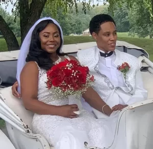 Wedding officiant Indianapolis LGBTQ of two women in a horse carriage holding red flowers