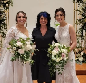 Indianapolis Wedding Officiant in a black dress with two women holding flowers in white dresses