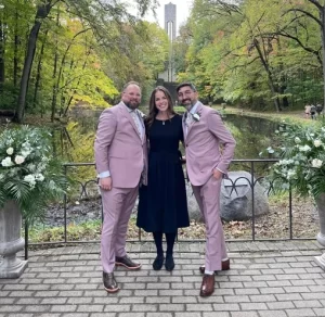 Officiant Indianapolis LGBTQ two men in pink suits with the officiant in a black dress