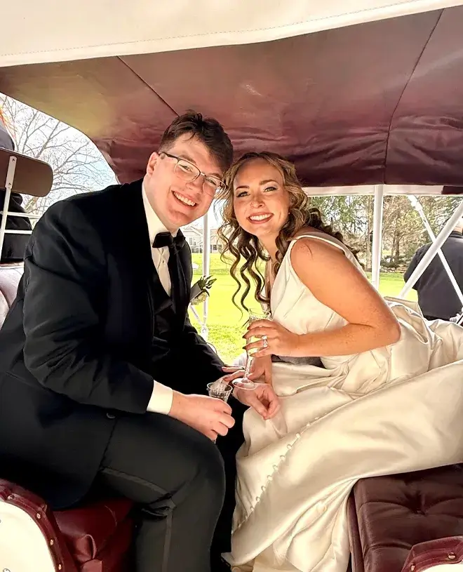 Bride and groom celebrating in a vintage car after their wedding