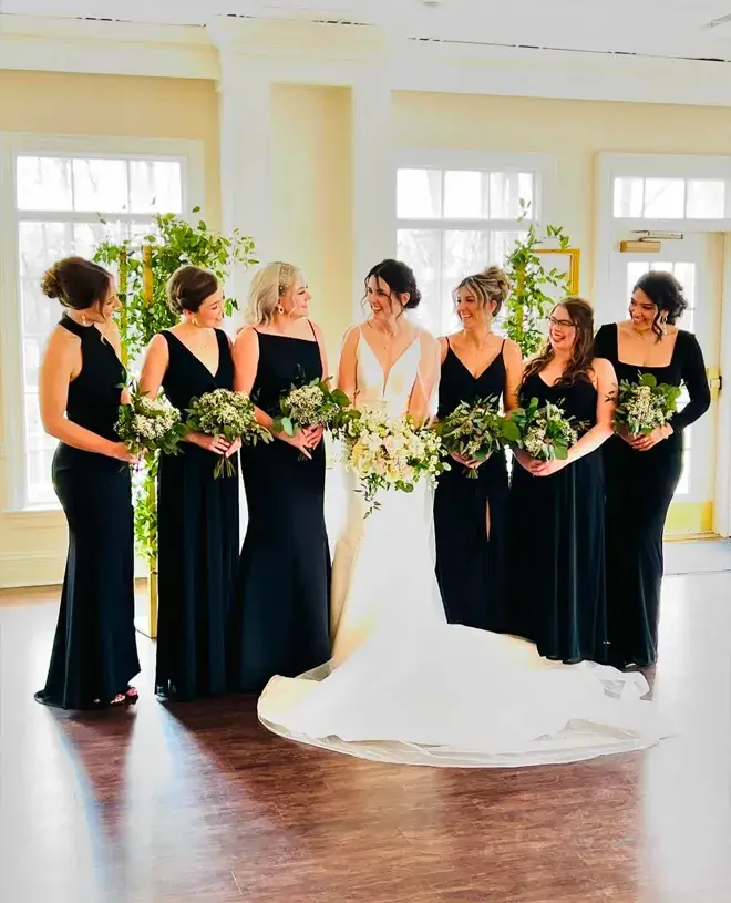 Weddings By Bretta Blog IMG 1 Bride with her bridesmaids in black dresses in a bright room