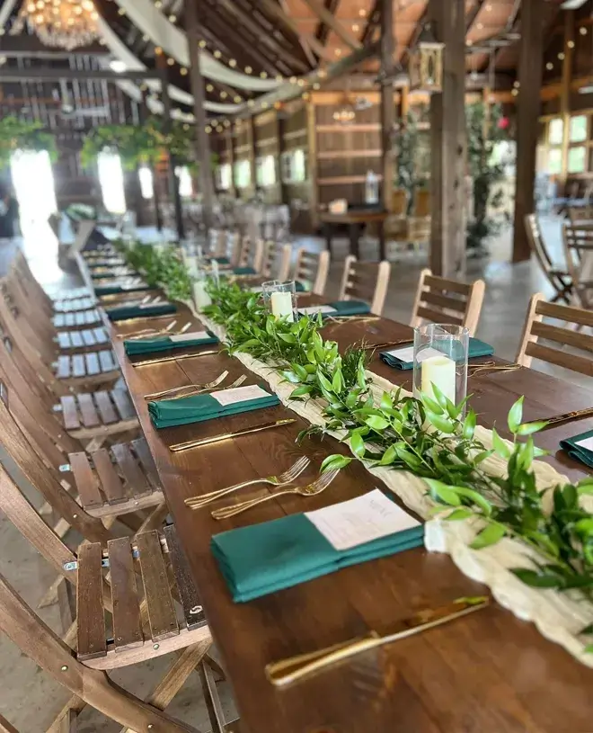 Weddings by Bretta Blog IMG 2 Long reception tables with greenery runners in a draped barn