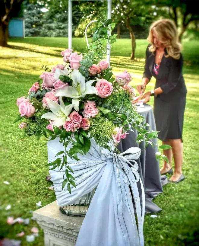 Weddings by Bretta Blog IMG 3 Wedding coordinator setting up an outdoor floral arrangement