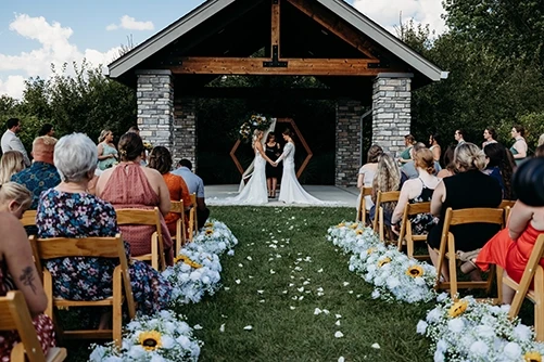 Couple exchanging vows under stone pavilion at The Sycamore at Mallow Run Bargersville Indiana, officiated and coordinated by Weddings by Bretta Indianapolis