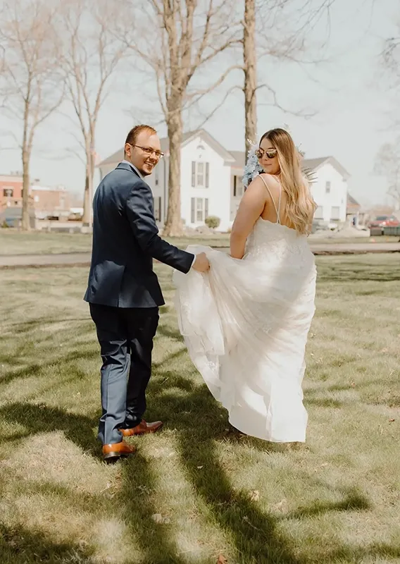 Bride and Groom at Folktale Venue Greenwood Indiana — Wedding Coordination by Weddings by Bretta Bride and groom walking together on lawn outside Folktale Venue in Greenwood Indiana — wedding coordination by Weddings by Bretta