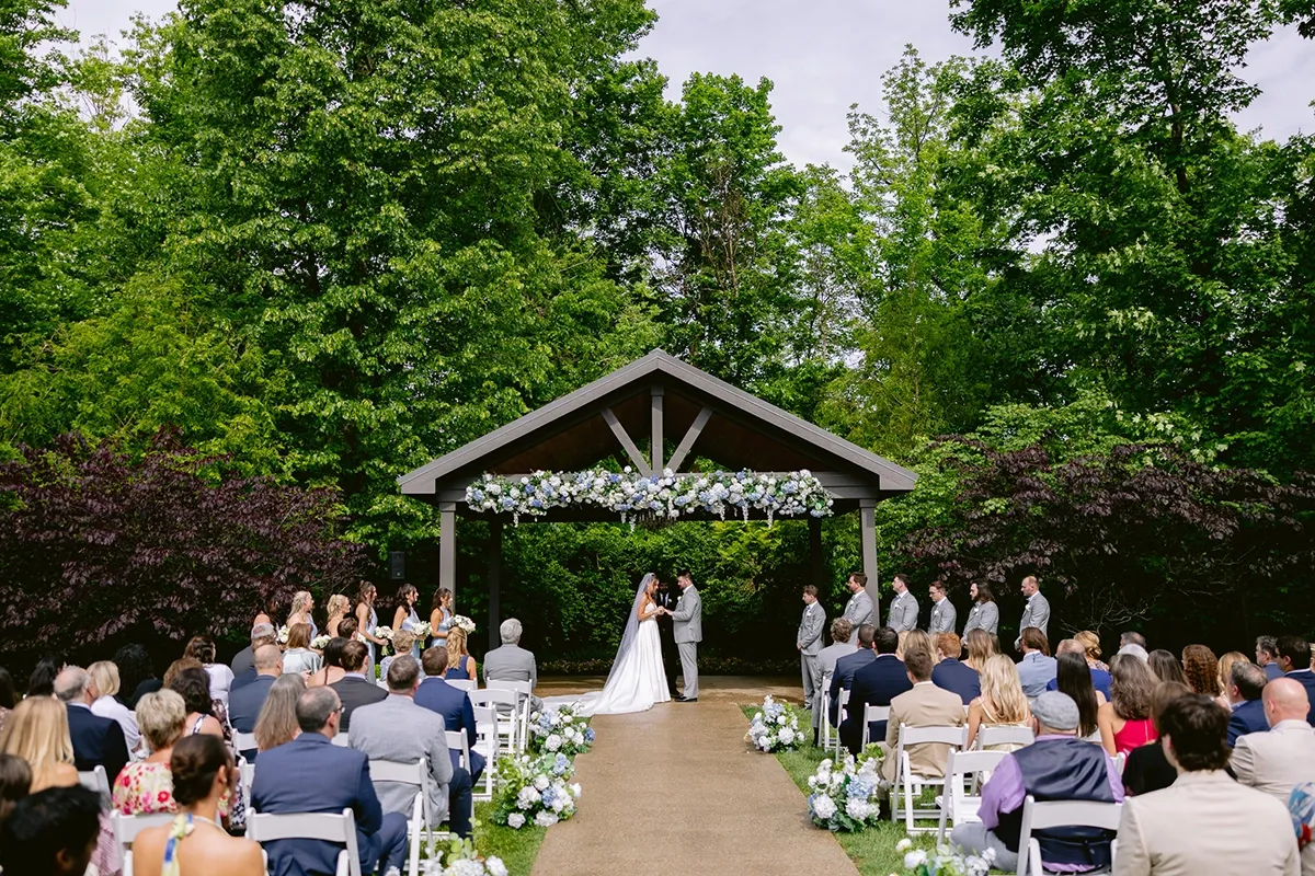 Outdoor Wedding Ceremony at Barn at Bay Horse Inn Pavilion | Weddings by Bretta Indianapolis Outdoor wedding ceremony under floral-decorated pavilion at Barn at Bay Horse Inn, planned and coordinated by Weddings by Bretta Indianapolis wedding planner