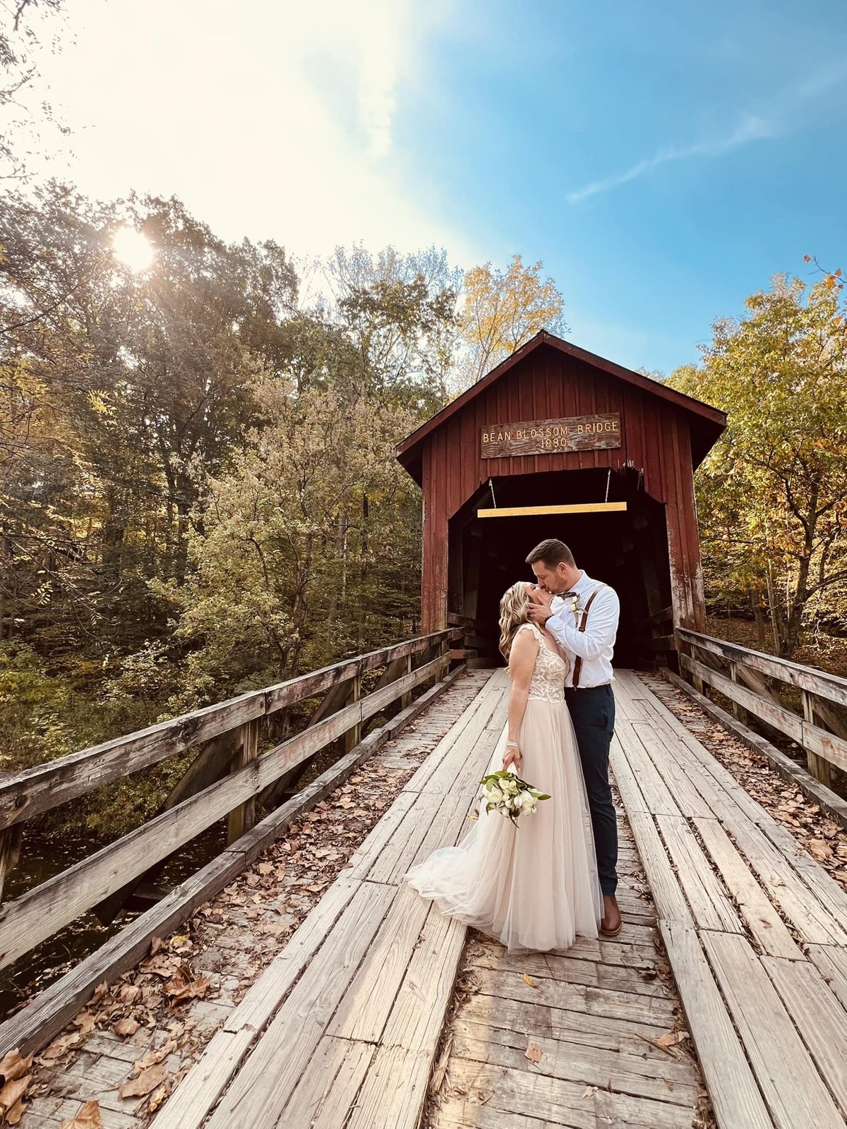 Bride and groom kissing on the Bean Blossom Covered Bridge in Brown County, Indiana