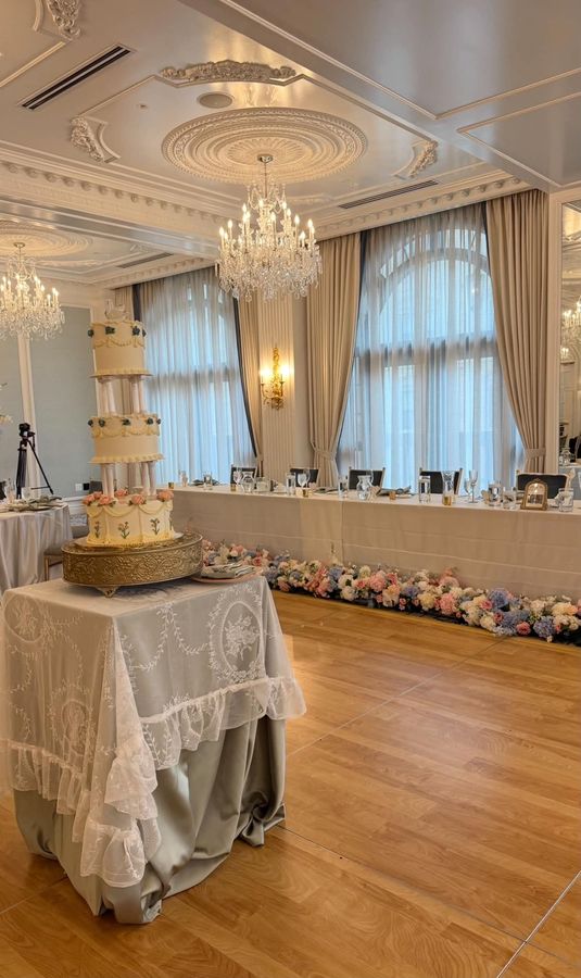 Tiered wedding cake and head table with floral garland at Hotel Carmichael, Carmel, Indiana