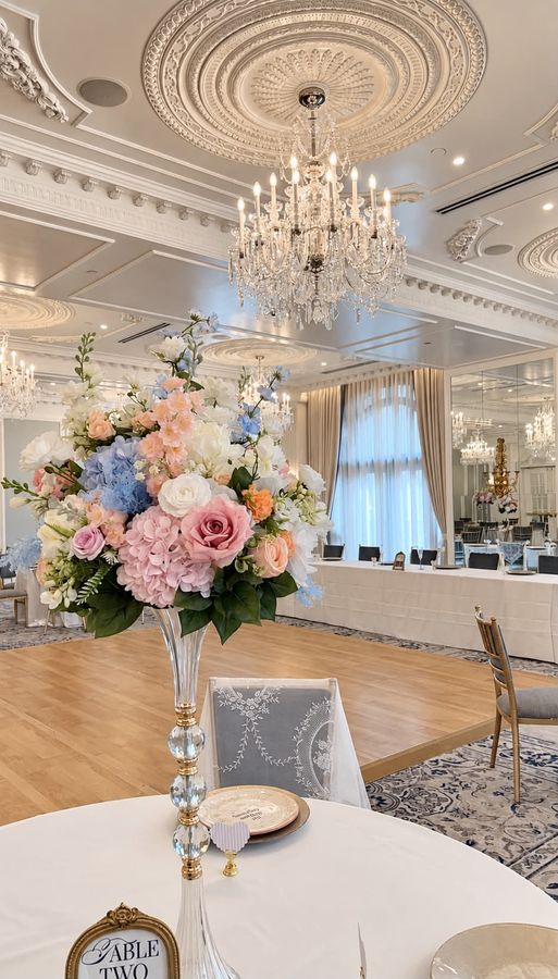 Tall floral centerpiece under crystal chandeliers at a Hotel Carmichael wedding in Carmel, Indiana