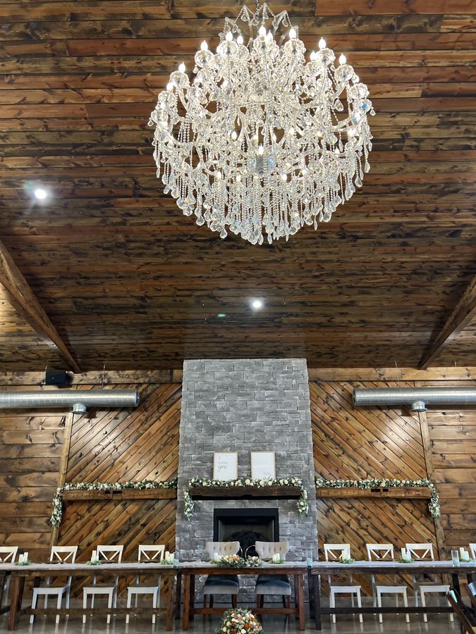 Wedding reception head table beneath a crystal chandelier in Indiana