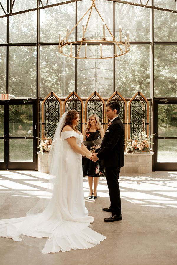 Bretta Thompson officiating a wedding ceremony in a glass chapel near Indianapolis