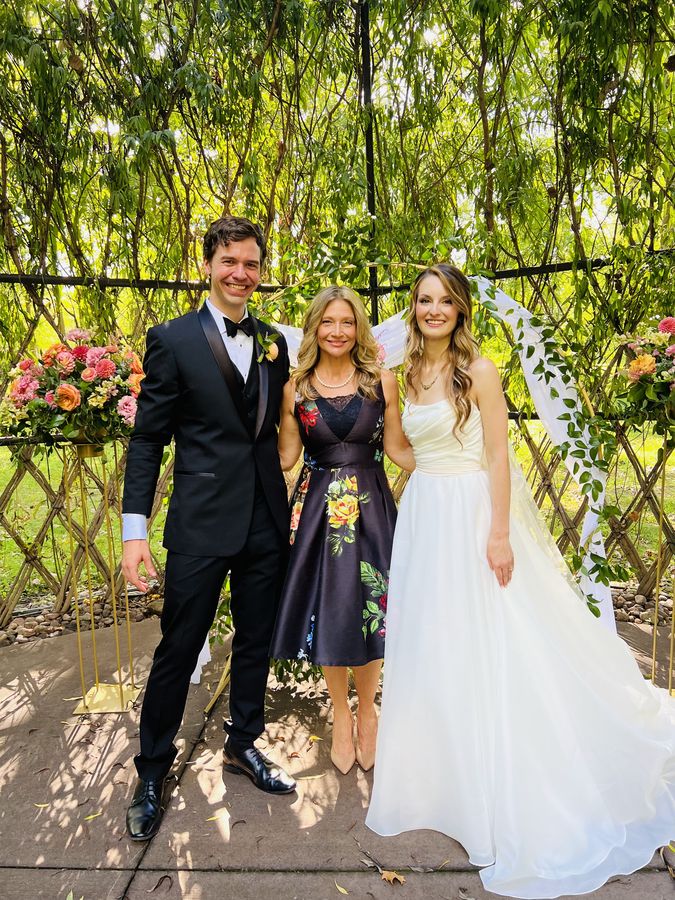 Bretta Thompson with a bride and groom after their Indianapolis garden wedding ceremony